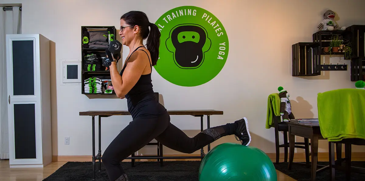 Denise demonstrating a lunge with a stability ball during personal training at Fit Monkeys in Carlsbad, California.